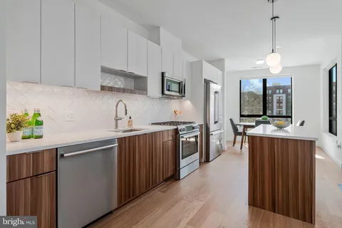 a kitchen with stainless steel appliances a sink stove and refrigerator