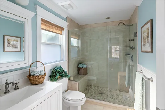 a bathroom with a granite countertop sink a toilet and shower