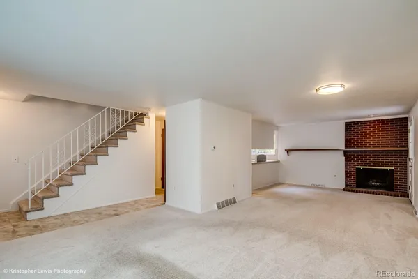 a view of empty room with fireplace and stairs