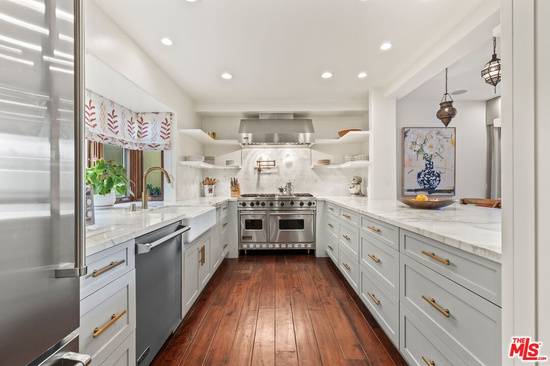 849 14th Street, Unit 8 Santa Monica, CA 90403 - Photo 4 of 19 a large kitchen with stainless steel appliances lots of counter space and wooden floor