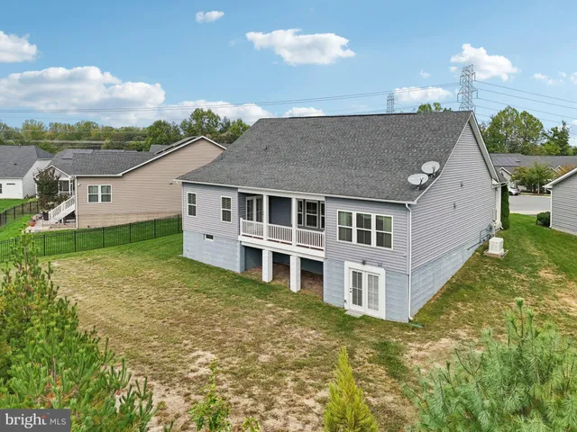 an aerial view of a house with outdoor space and lake view in back