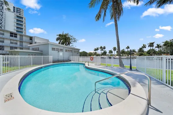 a view of a swimming pool with a patio and a yard