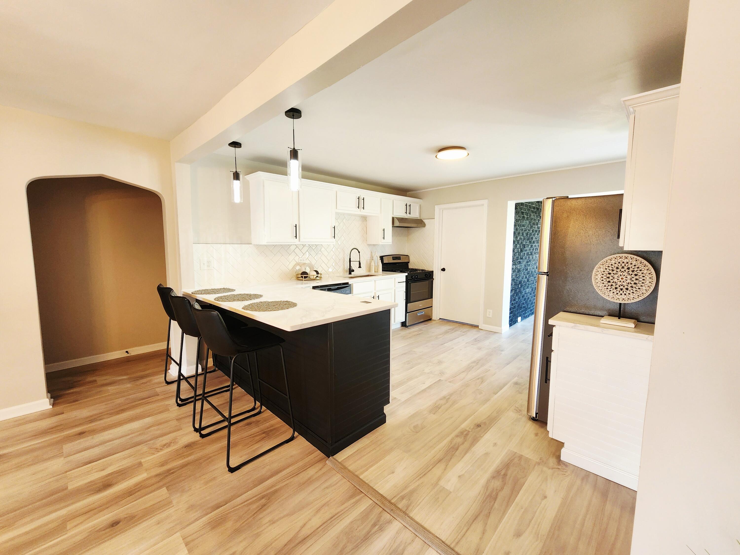 653 West Taft Street Gary, IN 46404 - Photo 5 of 16 a kitchen with a table chairs refrigerator and wooden floor