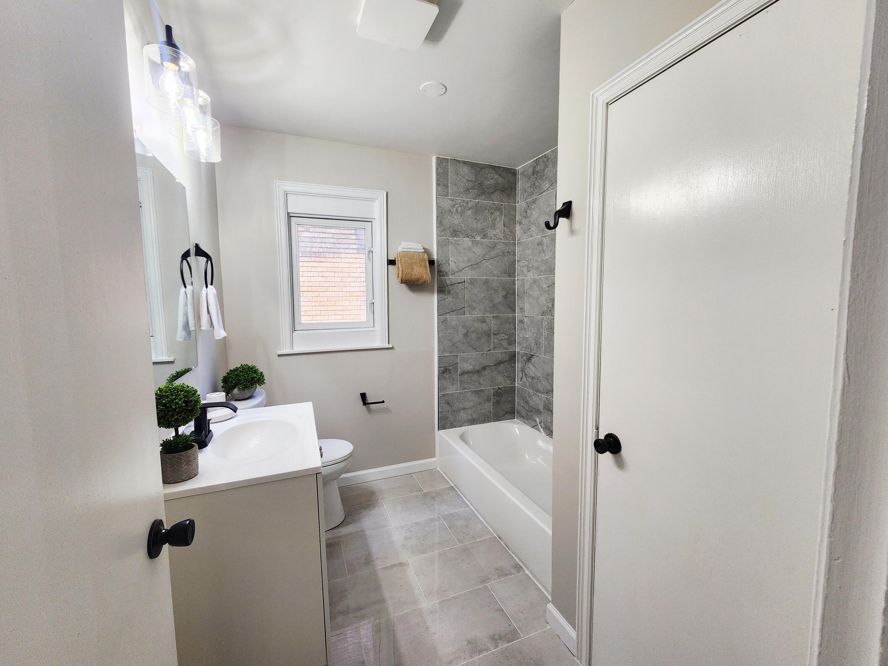 653 West Taft Street Gary, IN 46404 - Photo 8 of 16 a bathroom with a bathtub shower sink and mirror