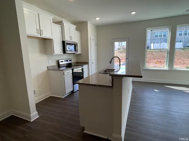 a kitchen with cabinets and wooden floor