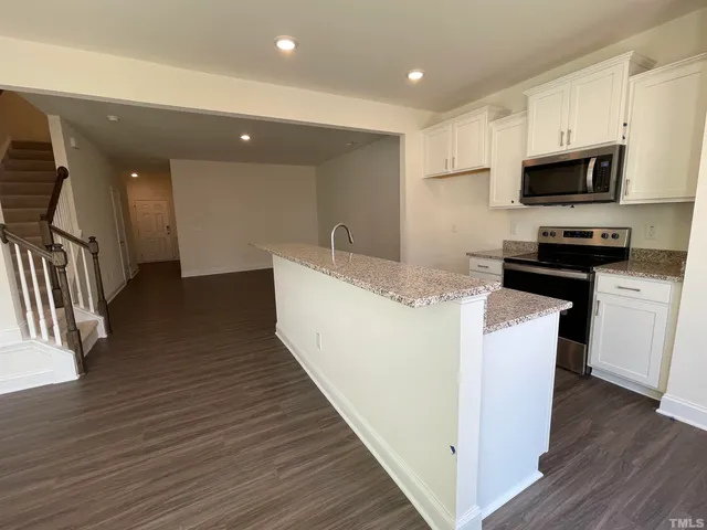 a kitchen with stainless steel appliances a refrigerator a stove top oven a sink and cabinets