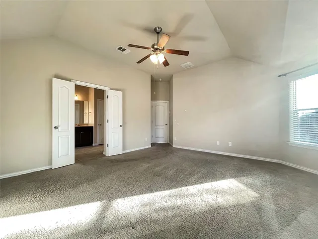 an empty room with fan and windows