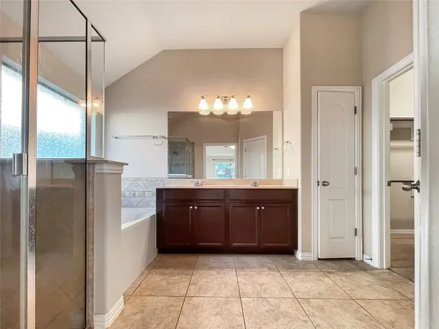 a spacious bathroom with a double vanity sink a mirror and a shower