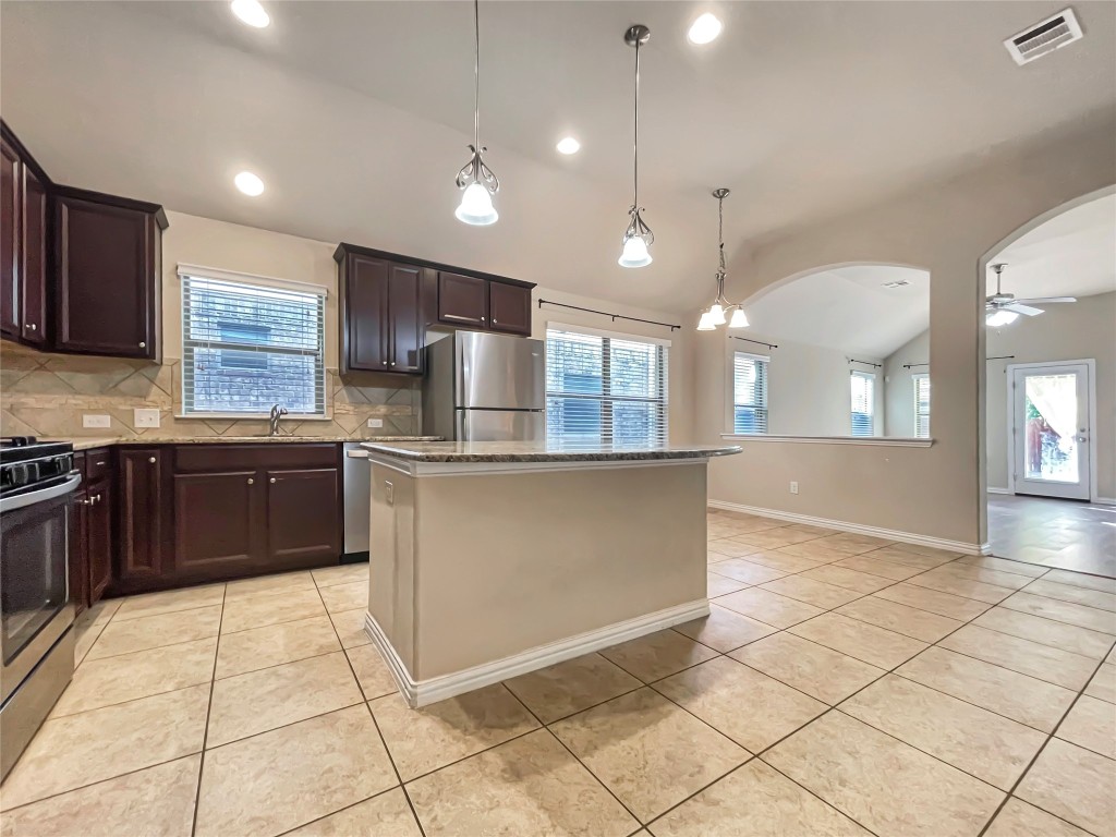 2468 Millbrook Loop Leander, TX 78641 - Photo 5 of 16 a kitchen with stainless steel appliances granite countertop a stove a sink a microwave and a refrigerator
