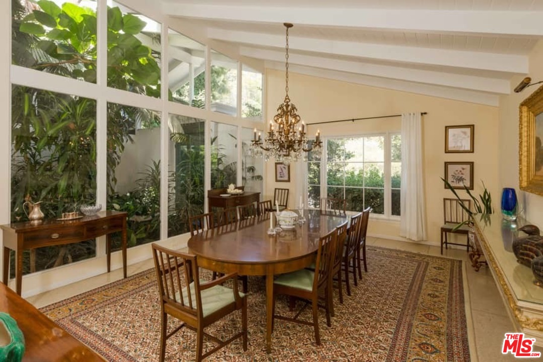 153 South Rockingham Avenue Los Angeles, CA 90049 - Photo 22 of 54 a view of a dining room with furniture wooden floor and a chandelier