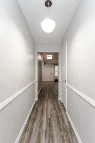 a view of a hallway with wooden floor