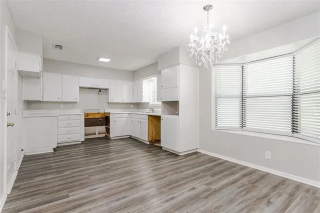 a kitchen with wooden floor and window