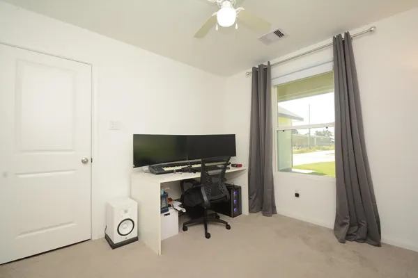 a view of a workspace with furniture and a window