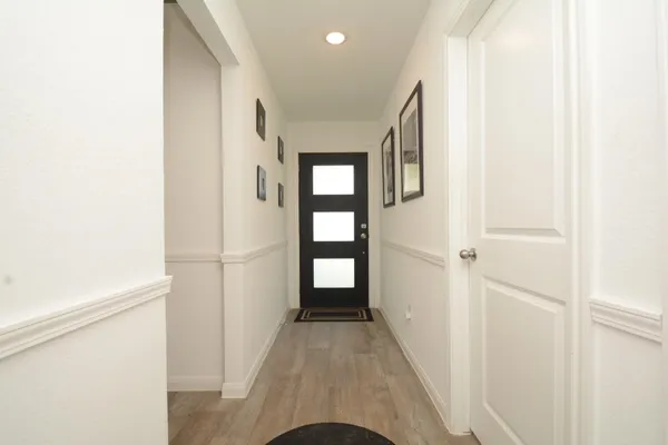 a view of a hallway with wooden floor and entryway