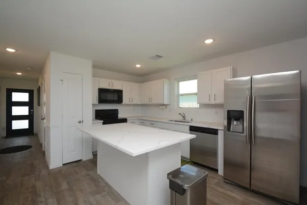 a kitchen with a refrigerator a sink and cabinets
