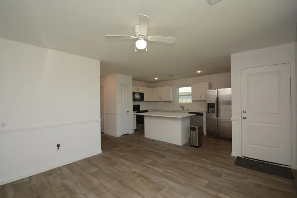 a kitchen with a refrigerator and white cabinets
