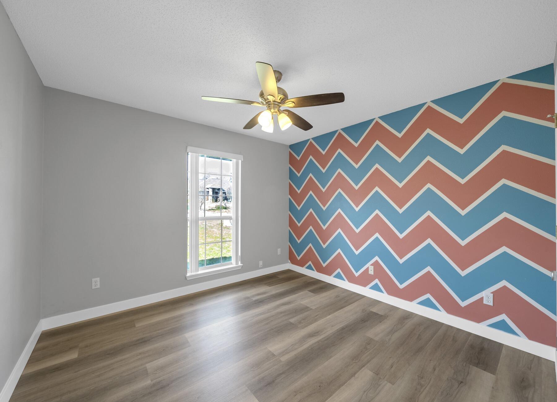 5130 Whitehurst Lane Crestview, FL 32536 - Photo 35 of 49 a view of an empty room with window and wooden floor