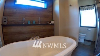 55 Old Goat Lane Sequim, WA 98382 - Photo 16 of 32 a bed sitting in a bathroom next to a window