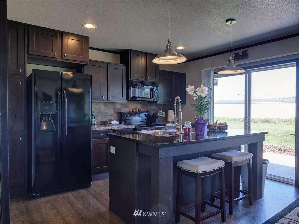 55 Old Goat Lane Sequim, WA 98382 - Photo 6 of 32 a kitchen with a table chairs refrigerator and cabinets