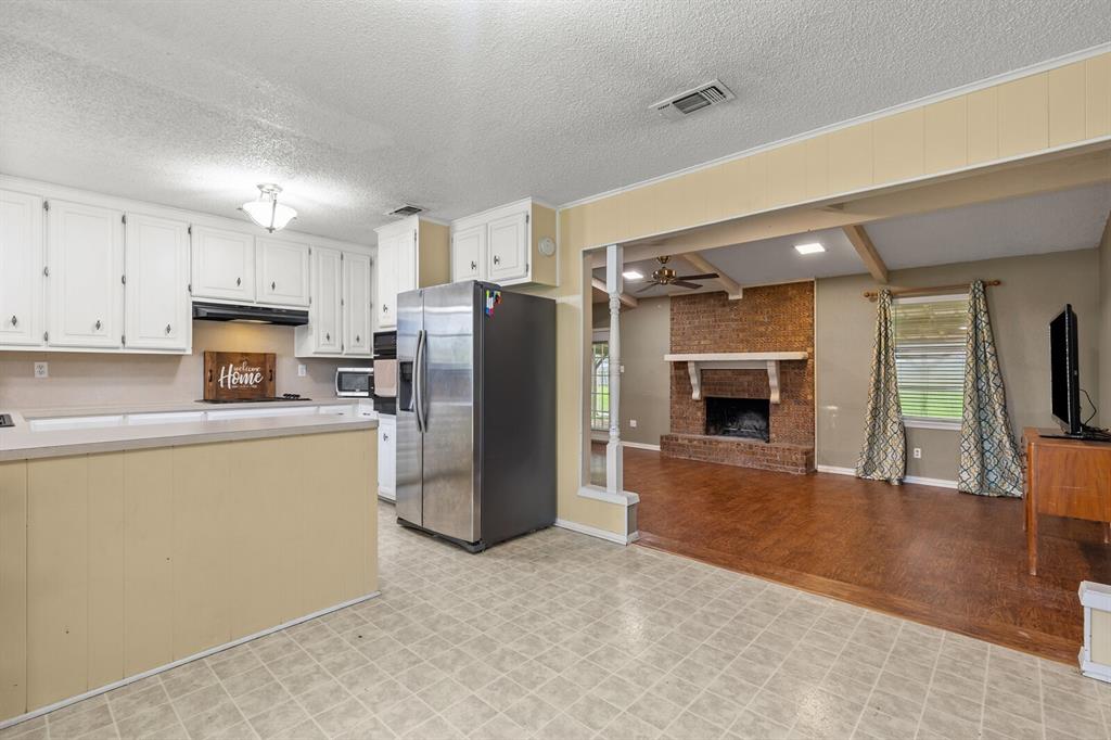 505 Pinewood Lane Hewitt, TX 76643 - Photo 7 of 38 Kitchen with white cabinetry and a built-in oven, featuring a bar-height countertop