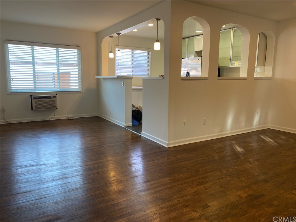 11767 Sunset Boulevard, Unit 202 Los Angeles, CA 90049 - Photo 11 of 23 an empty room with wooden floor and windows