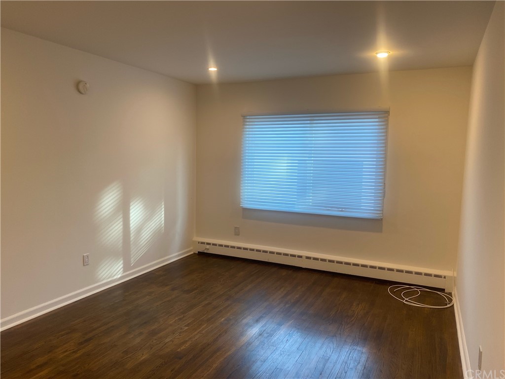 11767 Sunset Boulevard, Unit 202 Los Angeles, CA 90049 - Photo 16 of 23 an empty room with wooden floor and windows