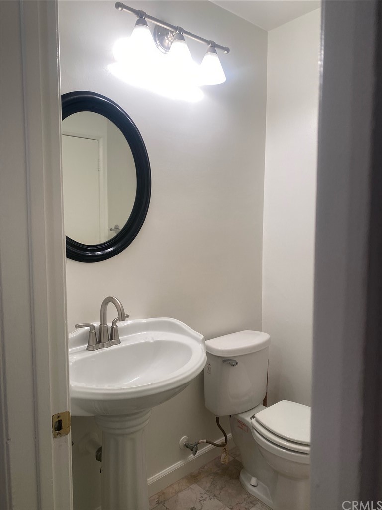 11767 Sunset Boulevard, Unit 202 Los Angeles, CA 90049 - Photo 20 of 23 a bathroom with a toilet sink and mirror