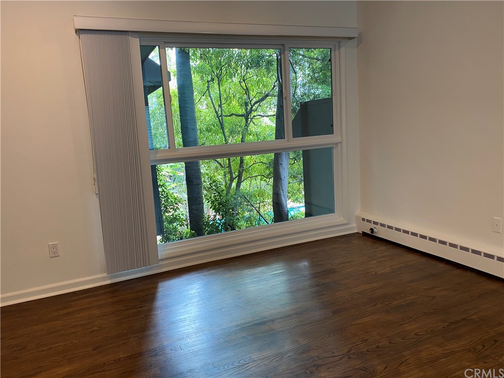11767 Sunset Boulevard, Unit 202 Los Angeles, CA 90049 - Photo 7 of 23 a view of an empty room with wooden floor and a window