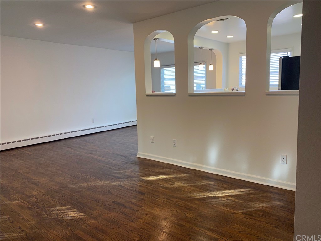 11767 Sunset Boulevard, Unit 202 Los Angeles, CA 90049 - Photo 9 of 23 an empty room with wooden floor and windows