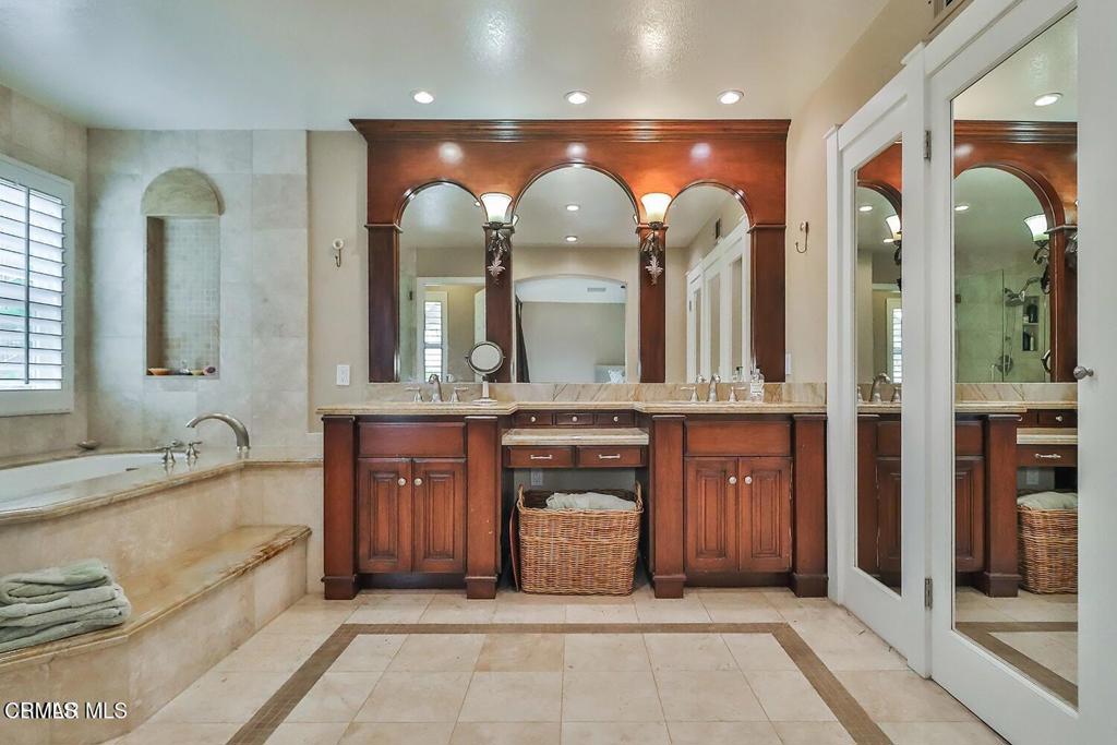 963 Corte Augusta Camarillo, CA 93010 - Photo 21 of 27 a bathroom with a granite countertop sink a mirror and a shower