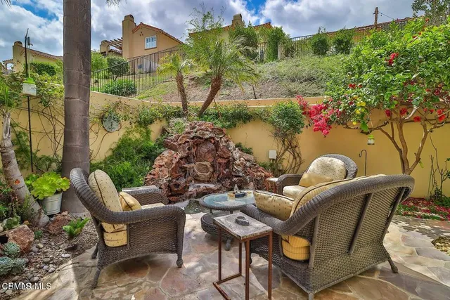 a view of a patio with a table and chairs under an umbrella