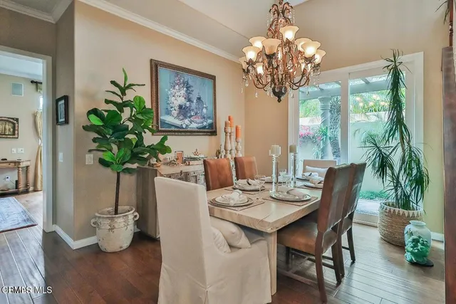 a dining room with furniture potted plants and wooden floor