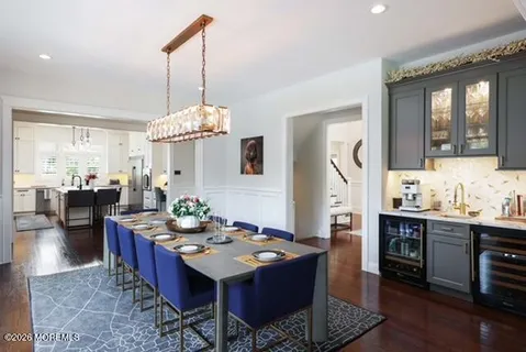 a kitchen with stainless steel appliances granite countertop a stove a sink dishwasher a refrigerator and a dining table with wooden floor