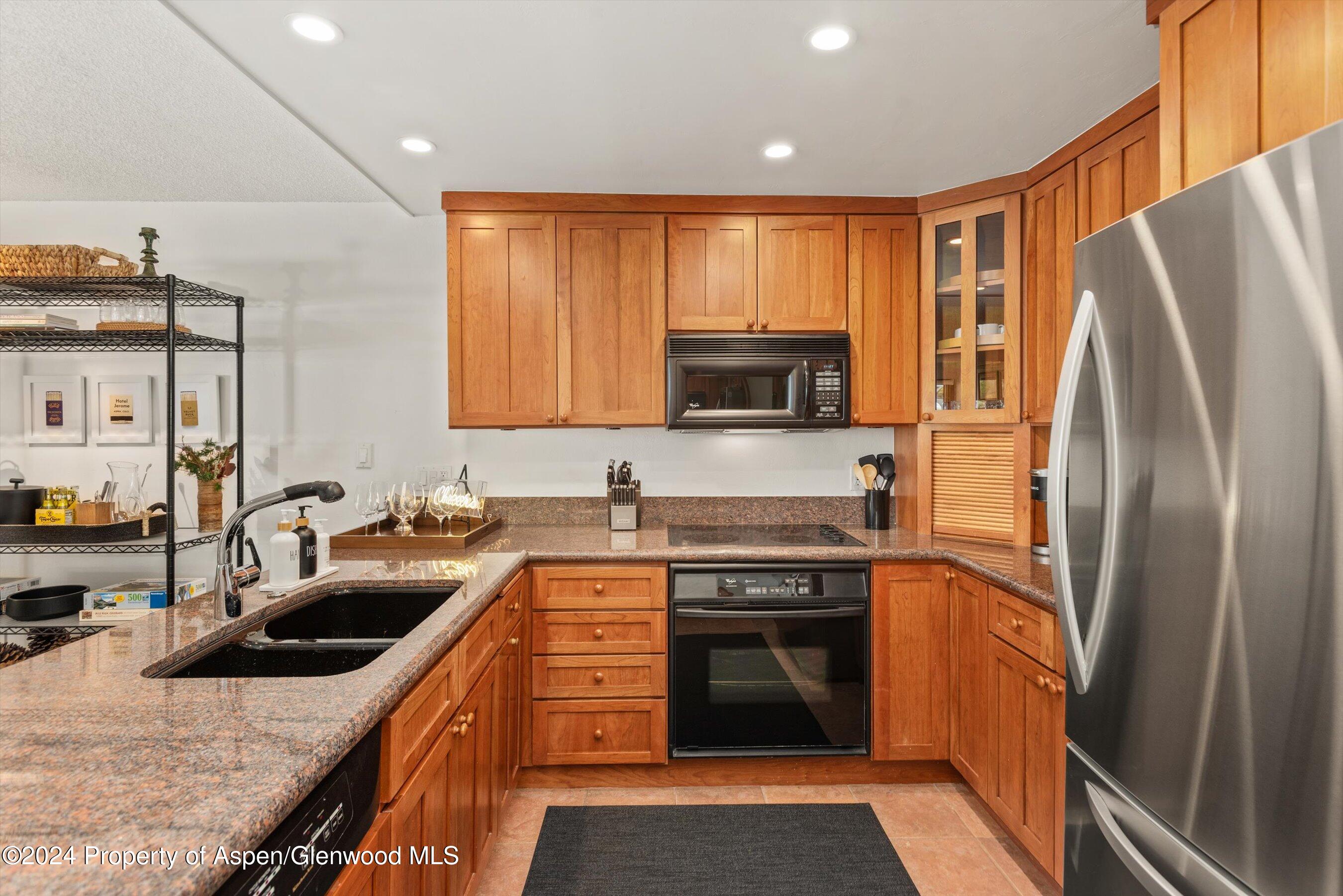 205 East Durant Avenue, Unit 1C Aspen, CO 81611 - Photo 4 of 12 a kitchen with stainless steel appliances granite countertop a refrigerator stove and sink
