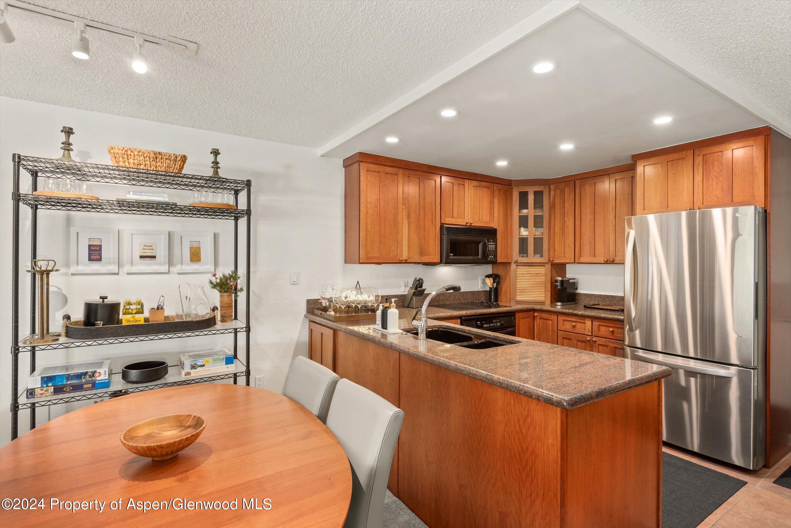 205 East Durant Avenue, Unit 1C Aspen, CO 81611 - Photo 5 of 12 a kitchen with stainless steel appliances granite countertop a refrigerator a stove top oven a sink and dishwasher