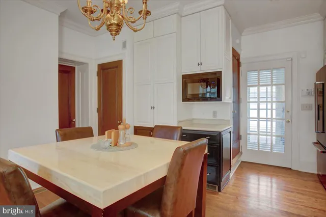 a kitchen with stainless steel appliances granite countertop a sink dishwasher a dining table and chairs with wooden floor