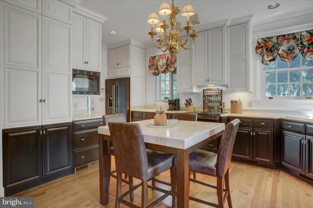 a kitchen with stainless steel appliances granite countertop a sink dishwasher stove and cabinets with wooden floor