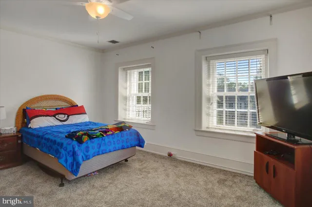 a spacious bedroom with a bed and a ceiling fan