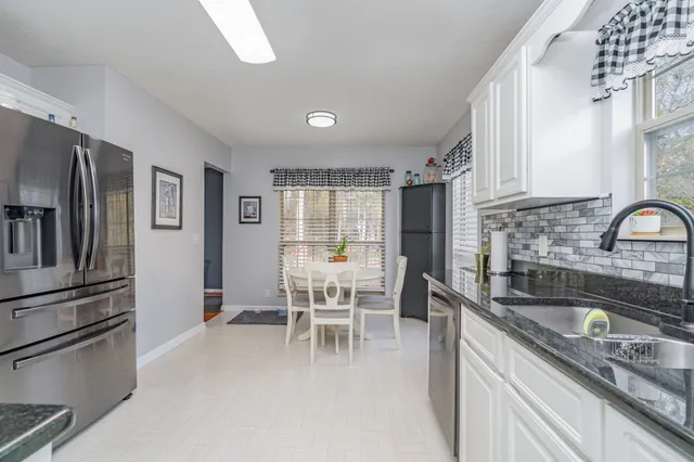 a kitchen with granite countertop a sink stove and refrigerator
