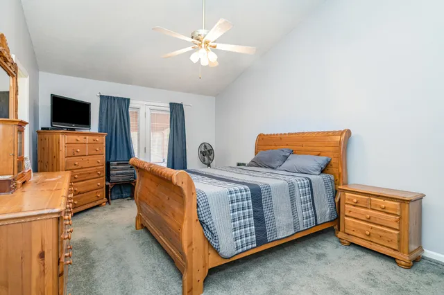 a spacious bedroom with a bed and wooden floor