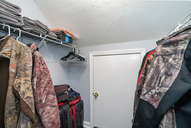 a view of walk in closet with clothes