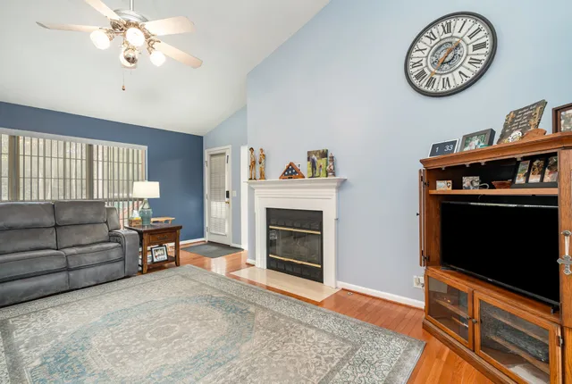 a living room with furniture a fireplace and a flat screen tv