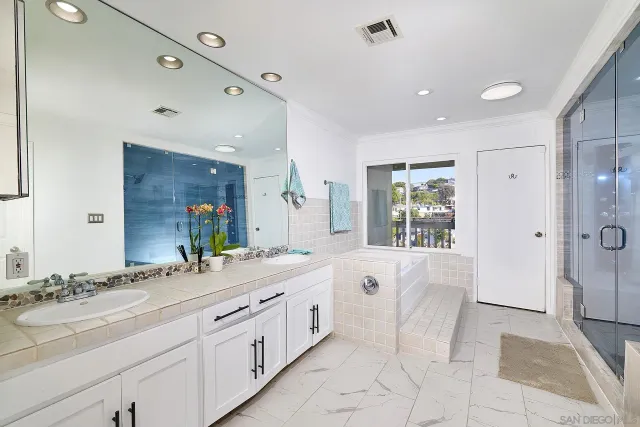 a spacious bathroom with a granite countertop sink mirror and shower