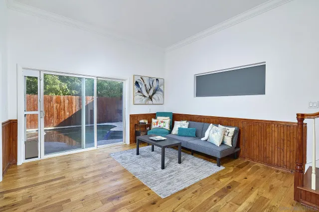 a living room with furniture a rug and a wall painting