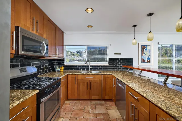 a kitchen with stainless steel appliances granite countertop a sink stove and microwave
