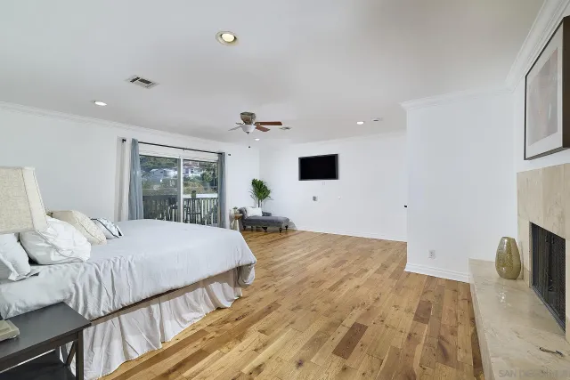 a bedroom with a large bed and a flat tv screen