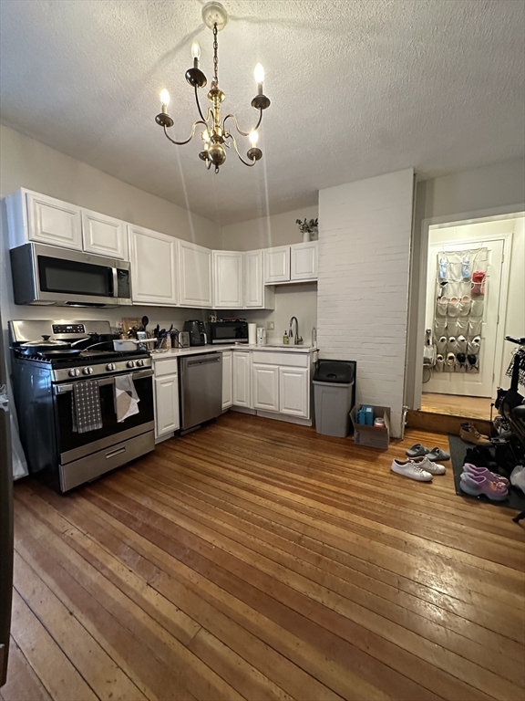 47 Wallingford Road, Unit 1 Boston, MA 02135 - Photo 1 of 16 a kitchen with stainless steel appliances granite countertop a stove and a refrigerator