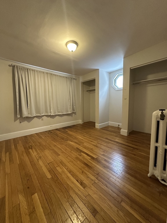 47 Wallingford Road, Unit 1 Boston, MA 02135 - Photo 9 of 16 a view of an empty room with wooden floor