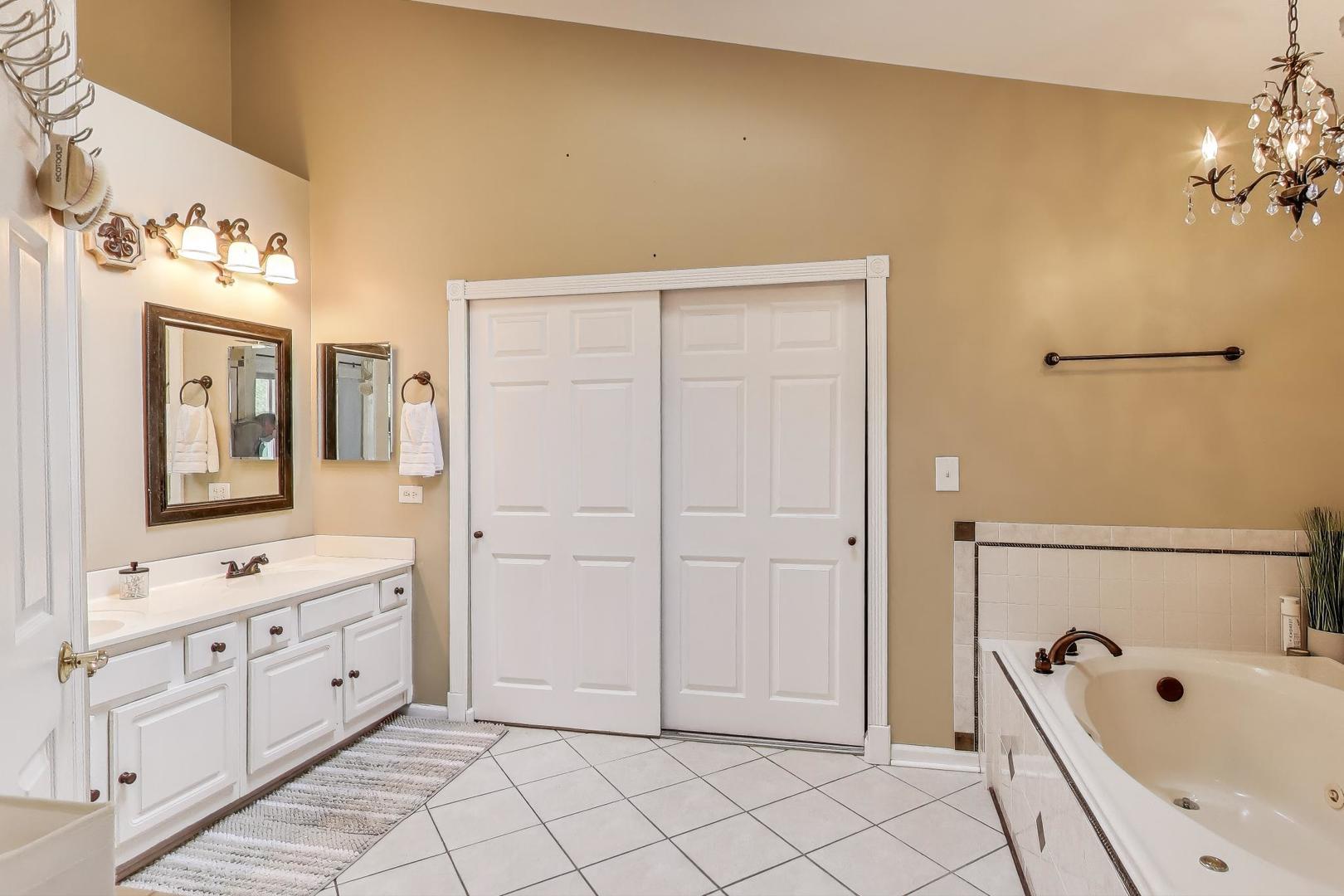 1010 Evergreen Street Mundelein, IL 60060 - Photo 17 of 28 a bathroom with a bathtub sink and mirror