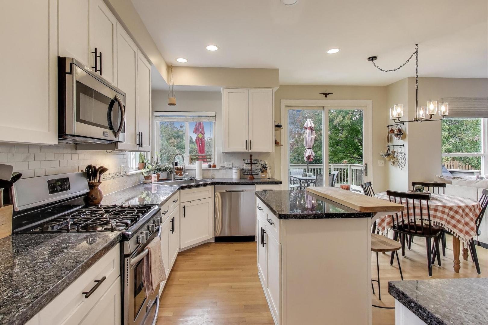 1010 Evergreen Street Mundelein, IL 60060 - Photo 8 of 28 a kitchen with stainless steel appliances granite countertop a stove top oven a sink dishwasher a dining table and chairs with wooden floor